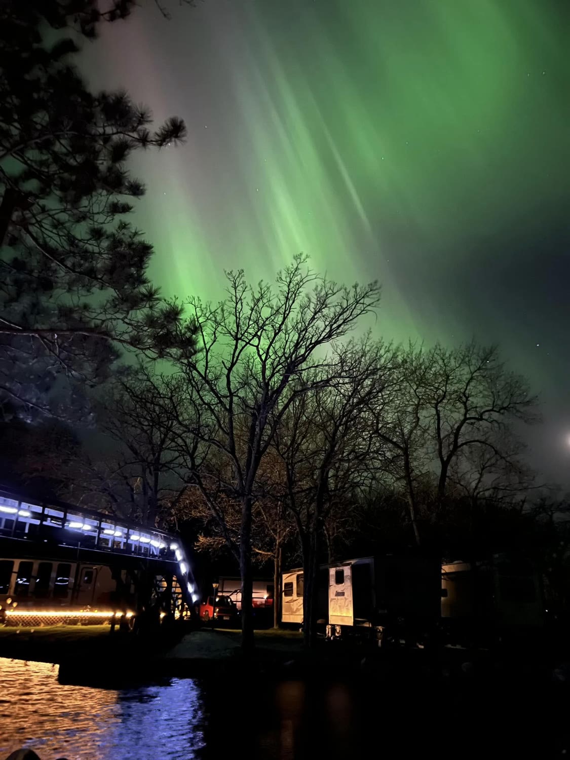 Northern lights glowing green over the harbor at Marclay Point on Cass Lake